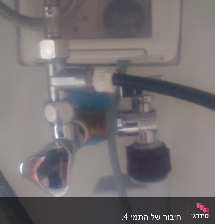 צינורות מתכת וברזים מתחת לכיור